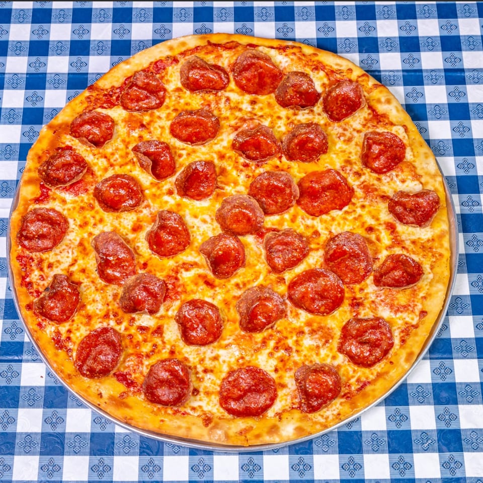 A large pepperoni pizza from Big Dog's Pizza on a blue and white checkered tablecloth.